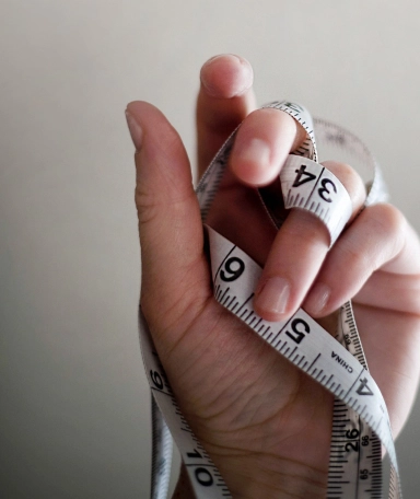 Hand holding measuring tape personal trainer 